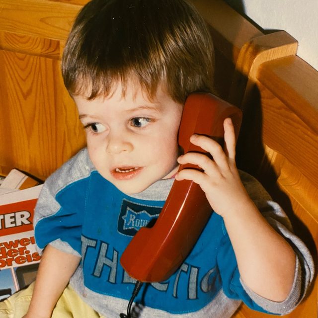 Marc als Kind mit rotem Telefon